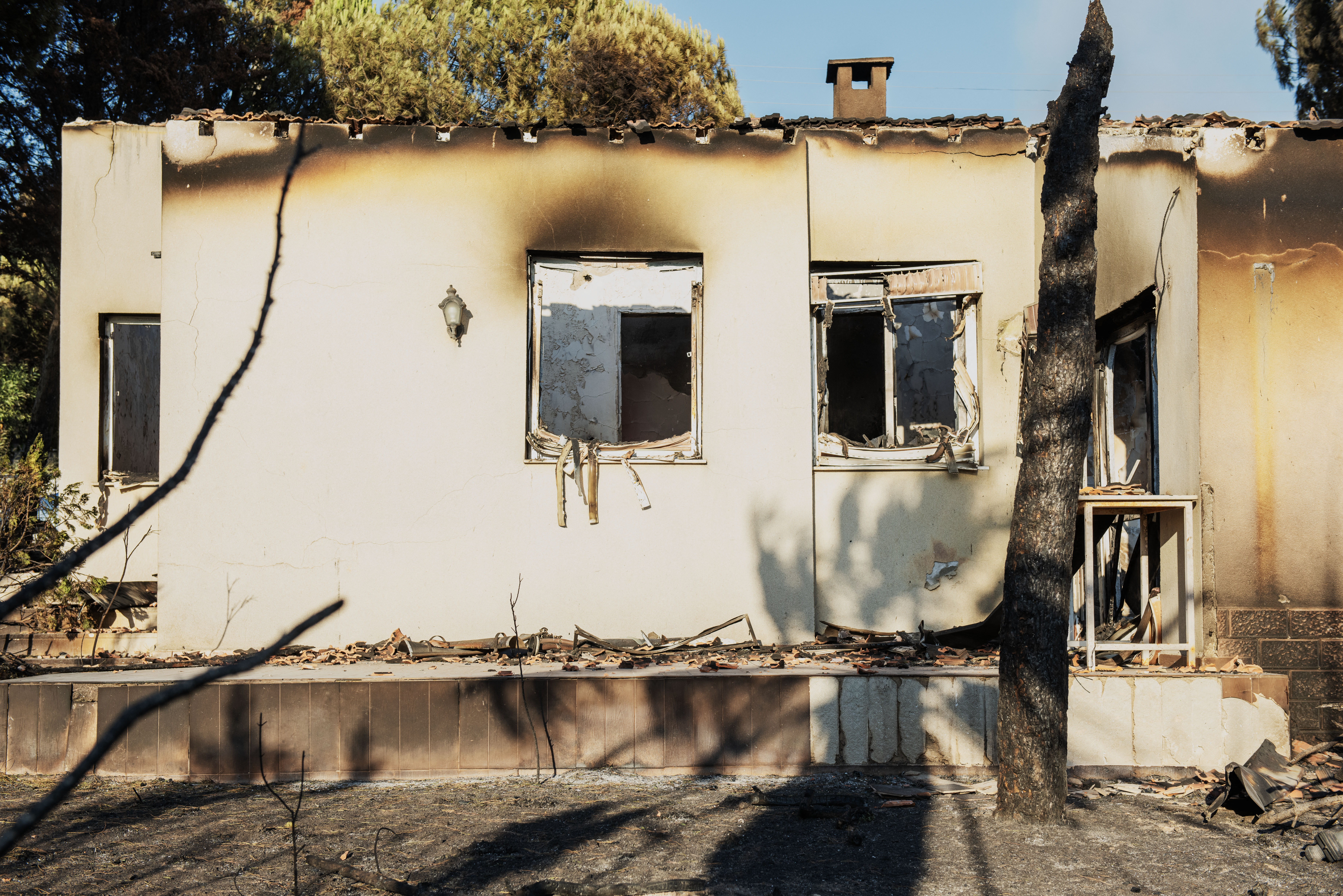 A burned house stands among debris following a wildfire in the Seferihisar district of Izmir, Turkey, on June 30, 2025