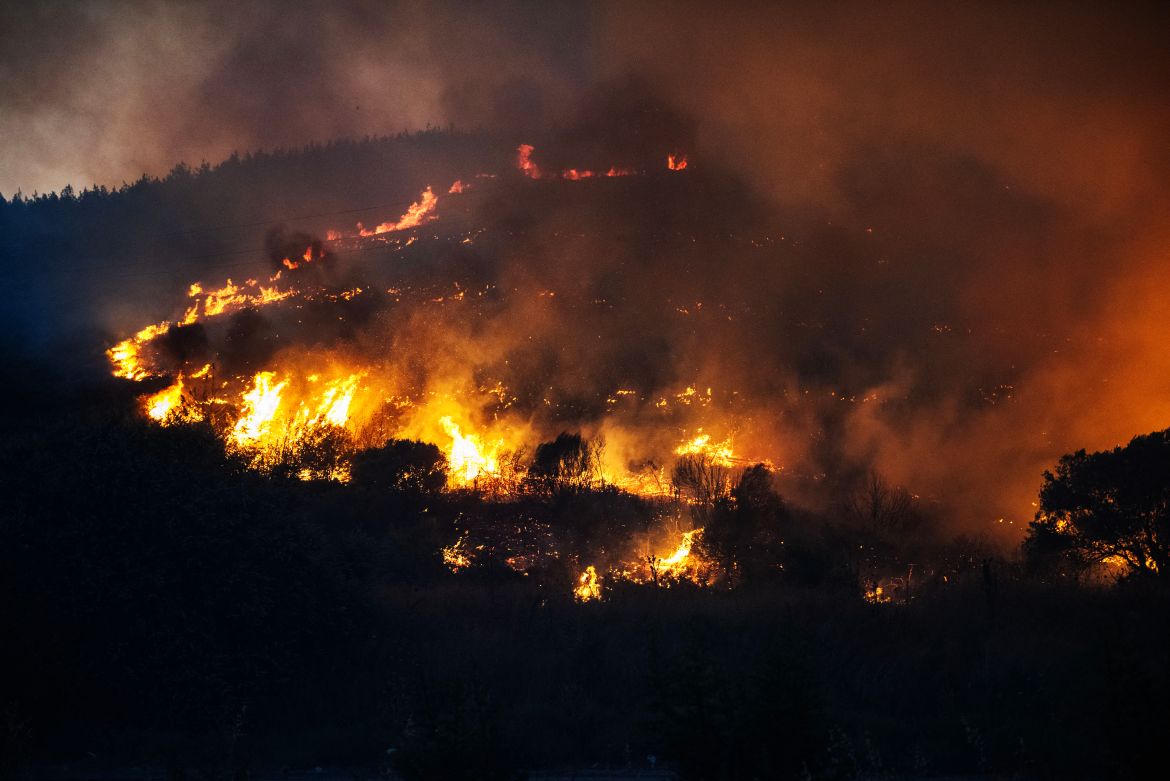 Smoke and flames rise from a forested area following a wildfire in the Seferihisar district of Izmir, Turkey, on June 30, 2025