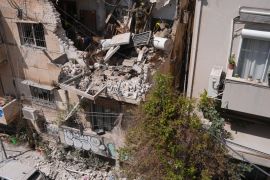 Israeli Home Front Command officers inspect an apartment building struck by an Iranian missile in Tel Aviv, Israel, Sunday, March 22, 2026. (AP Photo/Maya Levin)