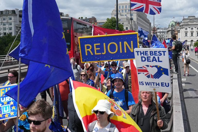 People wave flags and hold banners during a National 'Rejoin the EU' march in central London on June 20, 2026.